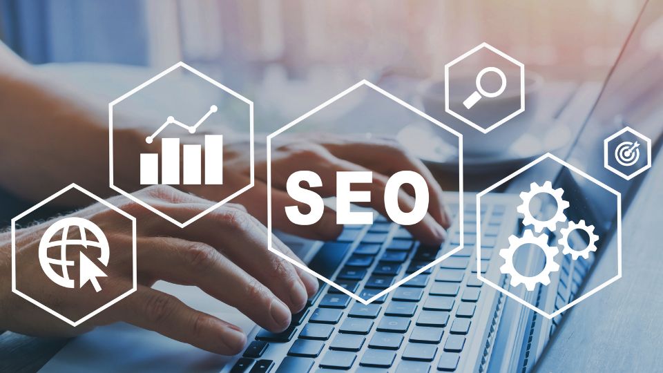 Egy felhasználó keze a laptop billentyűzetén, SEO grafikai elemekkel.