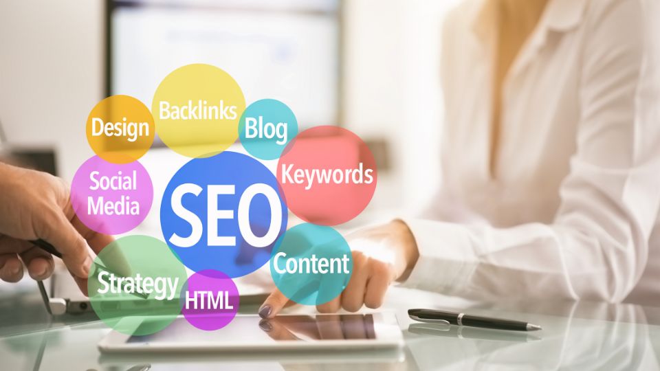 Két ember keze egy asztalon, SEO kulcsszavakkal körülvéve, digitális marketing kontextusban.