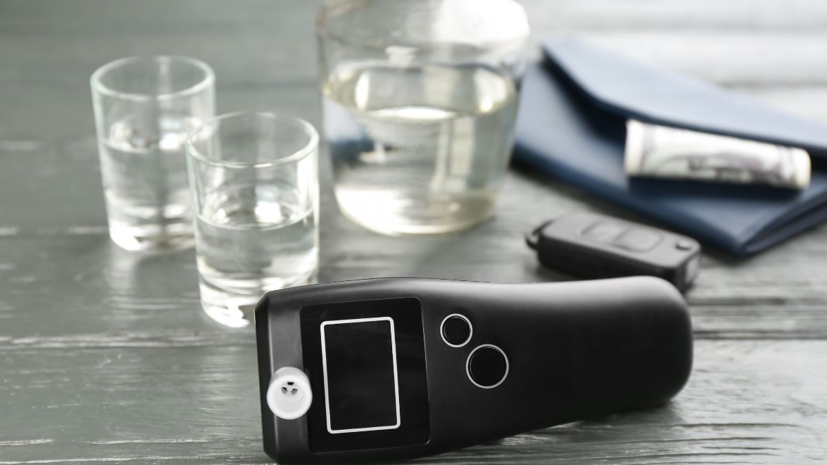 Egy digitális alkoholszonda, víz és egy kulcstartó mellett, biztonságos vezetéshez.