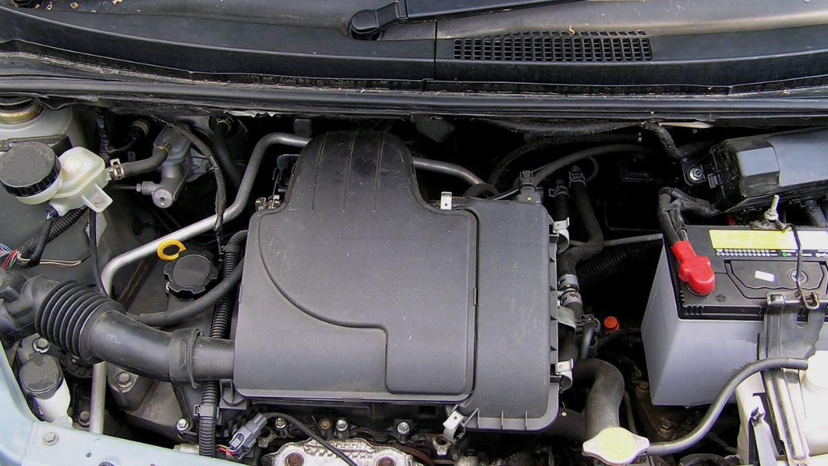 Egy háromhengeres motor részletei, látható a motorháztető alatt.