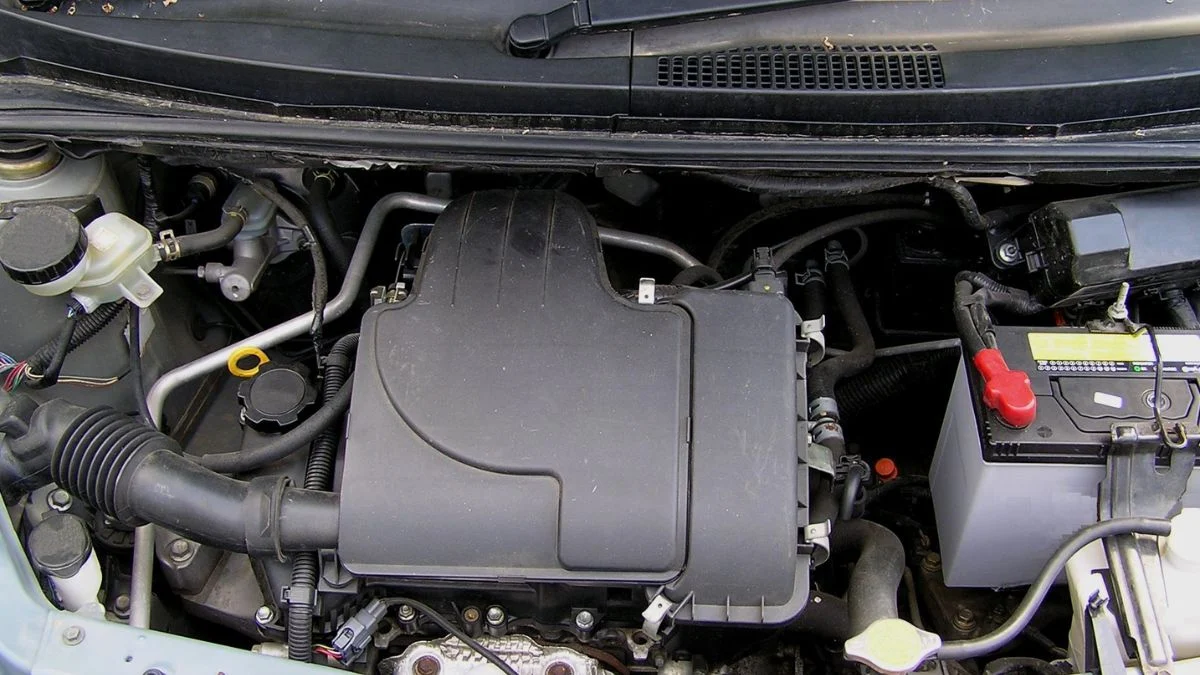 Egy háromhengeres motor részletei, látható a motorháztető alatt.
