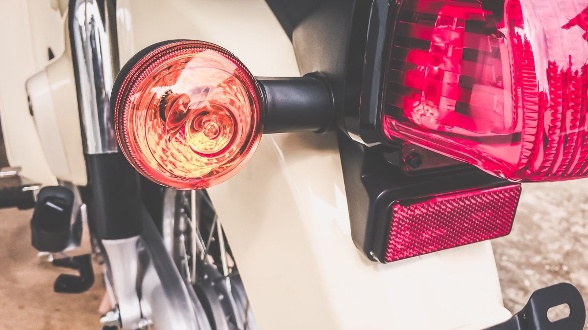 Egy motor hátsó irányjelző lámpája, narancssárga fényű, közelről.