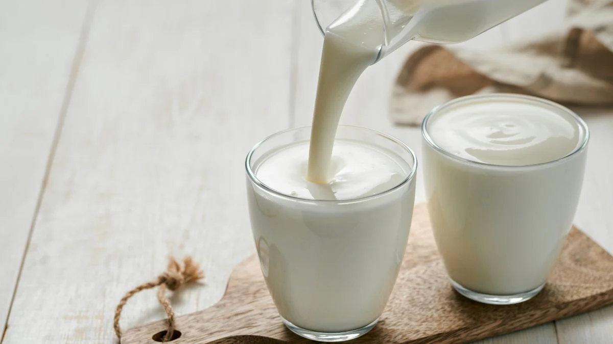 Kefir öntése egy pohárba, friss és krémes állagú ital.