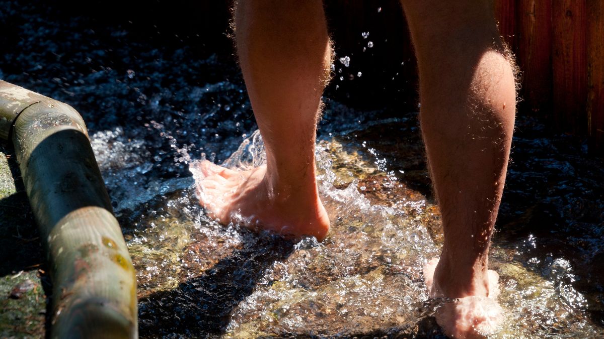 Egy ember lábai vízben, a Kneipp terápia frissítő hatásának bemutatása.