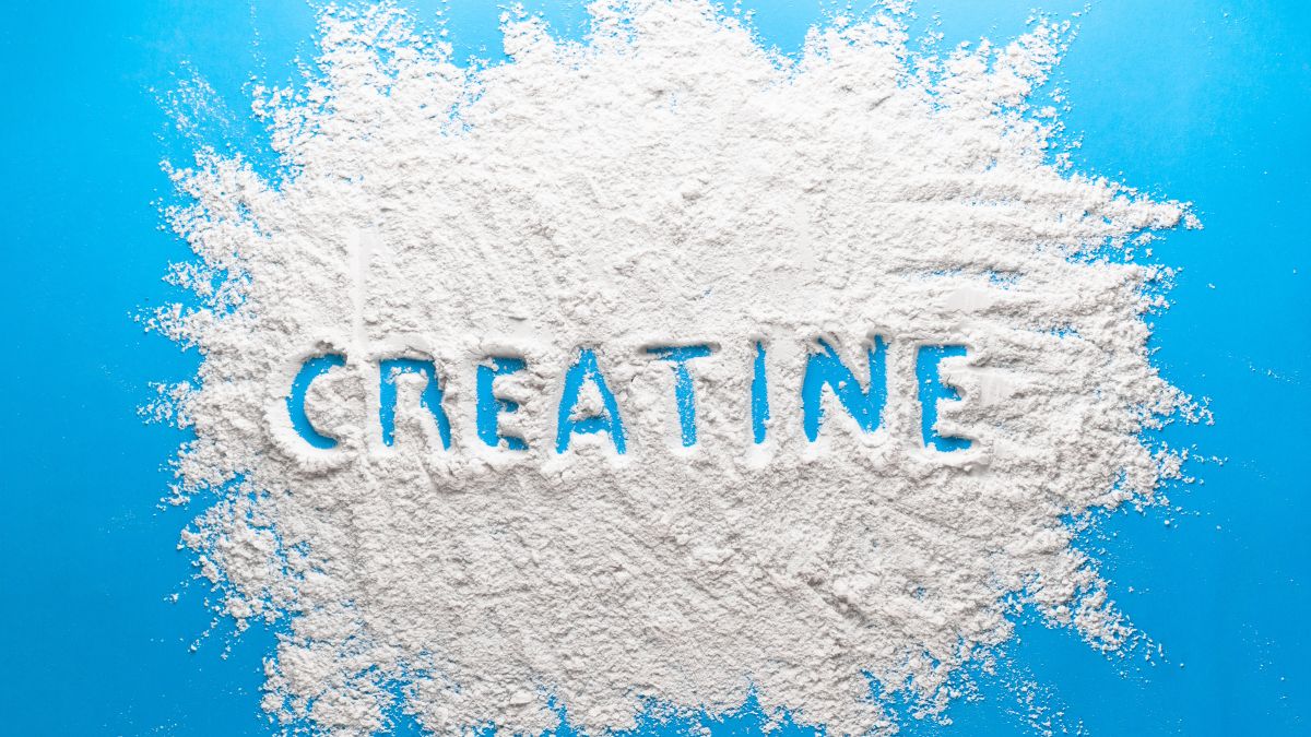 Fehér por, amelyből a 'CREATINE' felirat olvasható, kék háttéren.