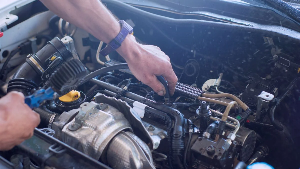 Egy kéz autómotor alkatrészeit szereli, hangsúlyozva a technológiai precizitást.
