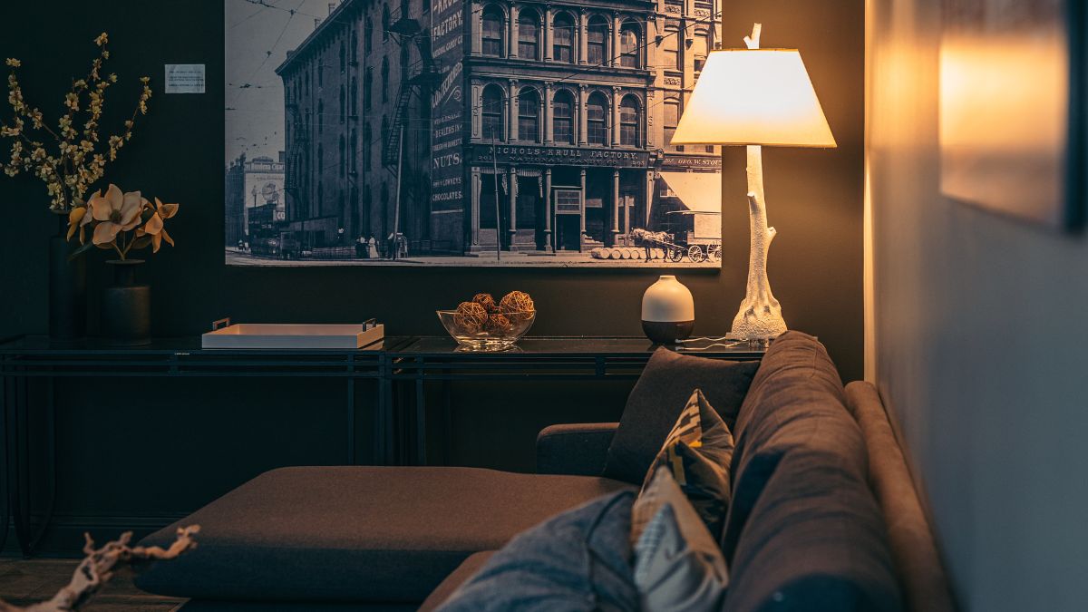 Egy modern nappali, napfénylámpával és vintage képpel a falon.