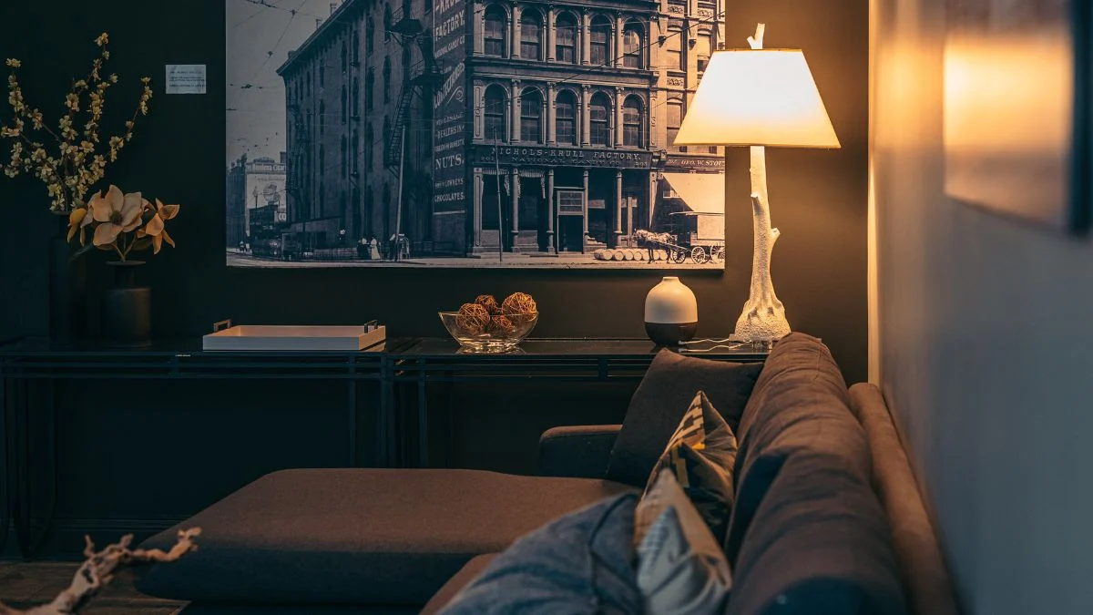 Egy modern nappali, napfénylámpával és vintage képpel a falon.