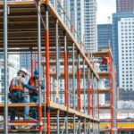 Munkavégzés építkezési csőállványon városi környezetben