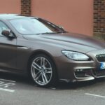 Egy használt BMW autó a parkolóban, ideális ellenőrzéshez vásárlás előtt.